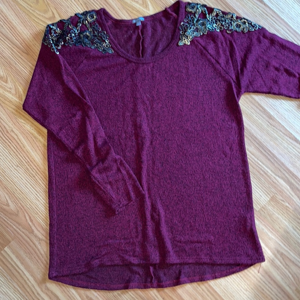 burgundy sweater with gold and black details on sleeve
